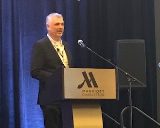Hans Eng speaks about hyperbaric oxygen therapy at a podium at HBOT 2019
